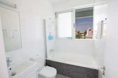 a bathroom with a toilet and a sink and a window at Greco Villas in Protaras