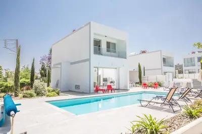 a villa with a swimming pool and a house at Greco Villas in Protaras