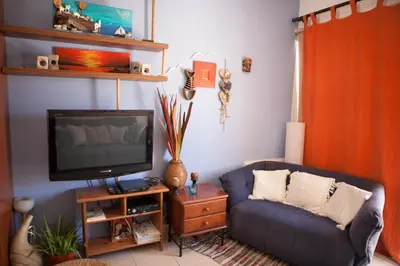 a living room with a blue couch and a tv at Aquarian Beachfront Apartment in Larnaka