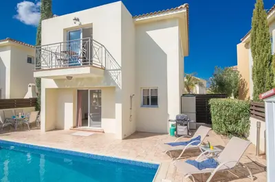 a villa with a swimming pool and a house at Nancy Villas in Protaras