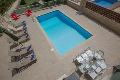 an overhead view of a swimming pool with tables and chairs at Shaye Front Line Villa in Protaras