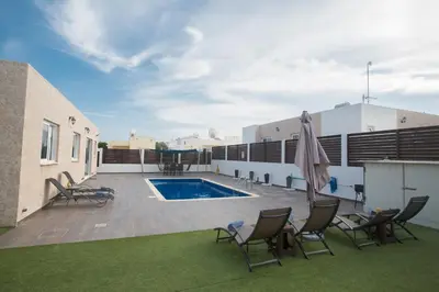 a patio with chairs and a swimming pool at Broadway Villas in Protaras