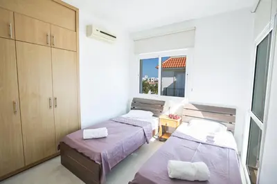 two beds in a room with a window at Halle Villa in Protaras
