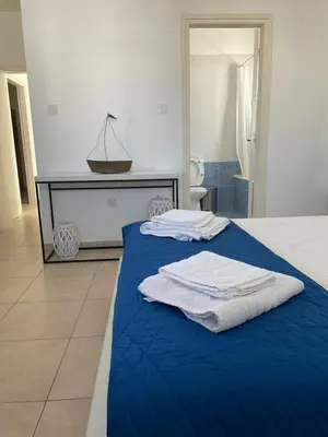 a bedroom with a blue bed with towels on it at Sol y Mar Malama Villa in Paralimni