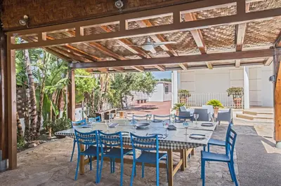 a patio with a table and blue chairs at Papas Family Villa in Paralimni