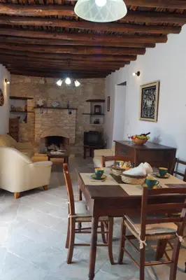 a living room with a table and a fireplace at Makrinari Tis Pano Geitonias in Salamiou