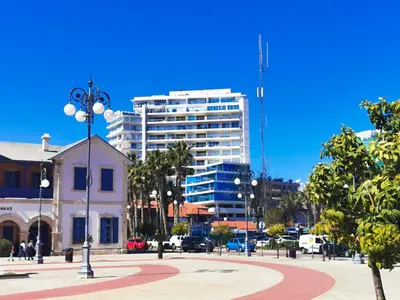 a city street with a tall white building in the background at Paradise Palms Seaview Apartment in Larnaka