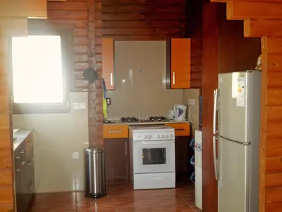 a kitchen with a white stove and a refrigerator at Agros Timber Log House in Agros