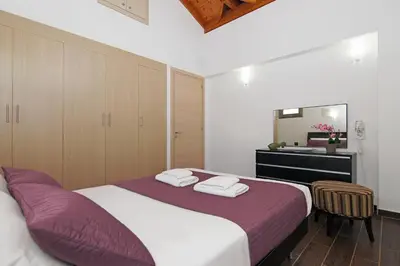 a bedroom with a bed and a vanity and a mirror at Villa Regina in Ayia Napa