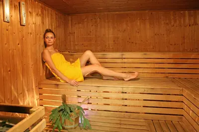 a woman is sitting in a sauna at Crowne Plaza Limassol by IHG in Limassol