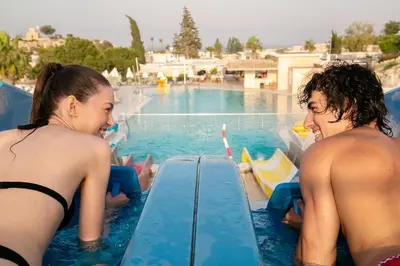a man and a woman in the water at a swimming pool at Louis St. Elias Resort & Waterpark in Protaras
