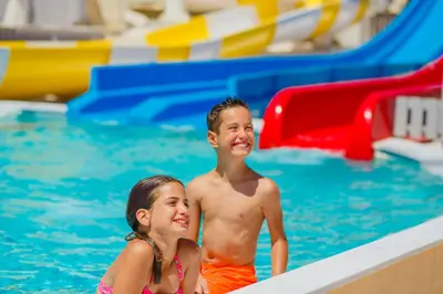 a boy and a girl in a swimming pool at Louis St. Elias Resort & Waterpark in Protaras