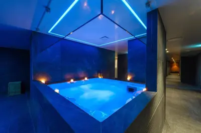a large swimming pool in a room with blue lighting at Ajax Hotel in Limassol