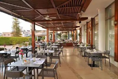 an empty restaurant with tables and chairs at Ajax Hotel in Limassol