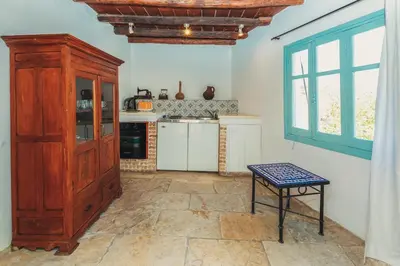 a kitchen with a large wooden cabinet and a table at Archondia House - Holiday Apartments With Pool in Kalavasos