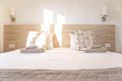 a large white bed with two pillows on it at Tikay Holiday Apts in Ayia Napa