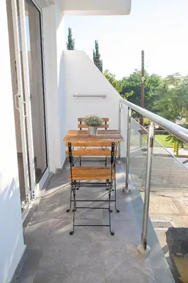 a wooden table and a chair on a balcony at Tikay Holiday Apts in Ayia Napa