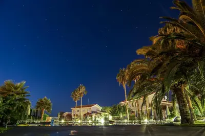 a group of palm trees in front of a building at Mon Repos Hotel in Ayia Napa