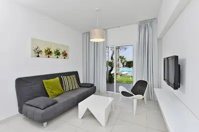 a living room with a couch and a tv at Mon Repos Hotel in Ayia Napa