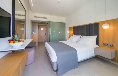 a hotel room with a large bed and a desk at Napa Mermaid Hotel & Suites in Ayia Napa