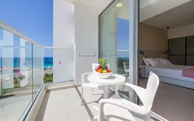 a bedroom with a bed and a table and chairs at Napa Mermaid Hotel & Suites in Ayia Napa