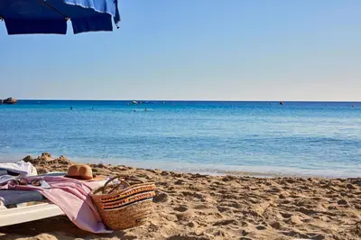 a person laying on a towel on a beach at Grecian Park in Protaras