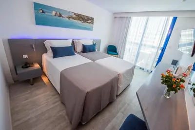 a hotel room with two beds and a table at Anonymous Beach Hotel (Adults 16+) in Ayia Napa