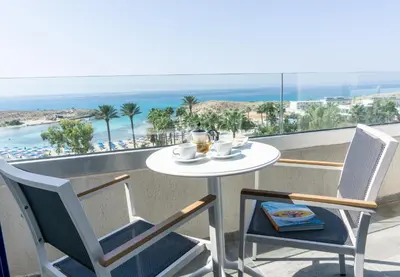 a table and chairs on a balcony with a view of the beach at Anonymous Beach Hotel (Adults 16+) in Ayia Napa