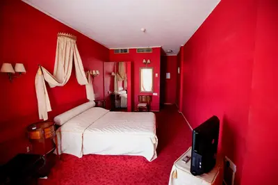 a red bedroom with a bed and a tv at Sylva Hotel in Limassol