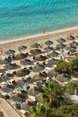 a beach with chairs and umbrellas and the ocean at Grecian Bay in Ayia Napa