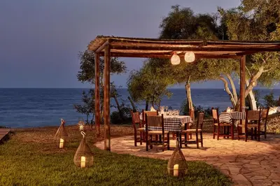 a table and chairs under a gazebo next to the ocean at Grecian Bay in Ayia Napa