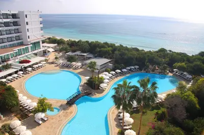 an aerial view of a resort with two pools and umbrellas at Grecian Bay in Ayia Napa