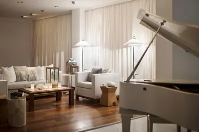 a living room with a couch and a piano at Grecian Sands Hotel in Ayia Napa