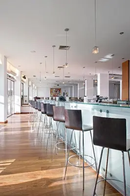 a row of bar stools in a large room at Grecian Sands Hotel in Ayia Napa