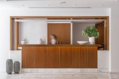 a person is standing behind a counter in a kitchen at Grecian Sands Hotel in Ayia Napa