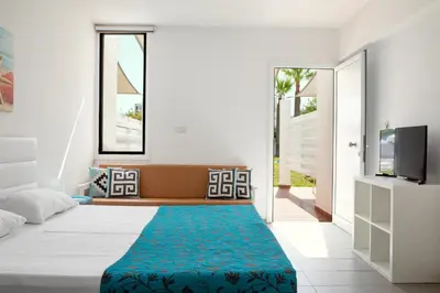 a bedroom with a bed and a blue rug at Lantiana Napa Aparthotel in Ayia Napa