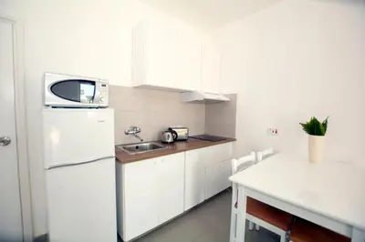 a white kitchen with a sink and a refrigerator at Lantiana Napa Aparthotel in Ayia Napa