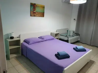 a bedroom with a purple bed and a chair at Sea Apartments in Larnaka