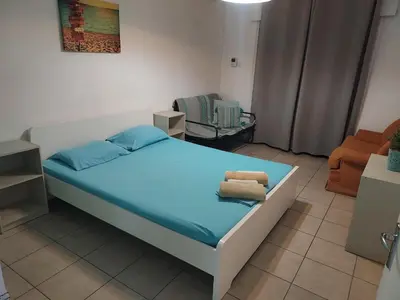 a small bedroom with a bed and a chair at Sea Apartments in Larnaka