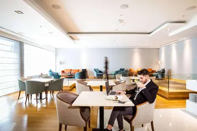 a man sitting at a table in a restaurant at Hilton Nicosia in Nicosia