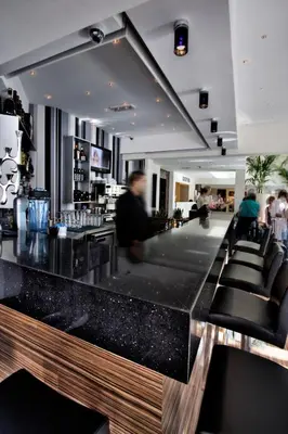 a bar with black granite counter tops in a restaurant at Livadhiotis City Hotel in Larnaka