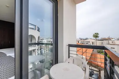 a balcony with a table and chairs and a window at Livadhiotis City Hotel in Larnaka