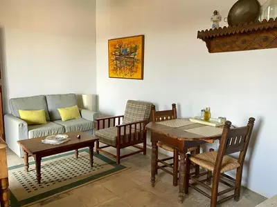 a living room with a couch and a table and chairs at Eveleos Country House in Tochni