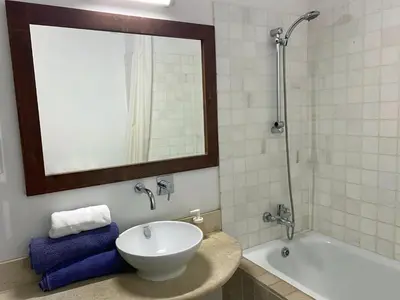 a bathroom with a sink and a tub and a mirror at Eveleos Country House in Tochni