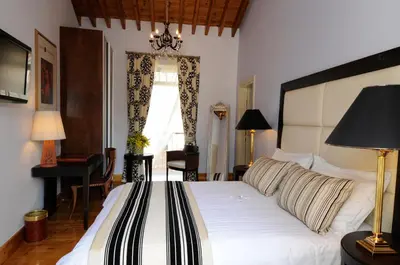 a bedroom with a large white bed and a piano at The Library Hotel Wellness Retreat in Kalavasos