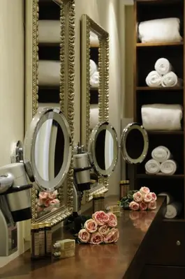 a bathroom with mirrors and roses on a counter at The Library Hotel Wellness Retreat in Kalavasos