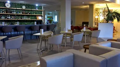 a restaurant with tables and chairs and a bar at Marina Hotel in Ayia Napa