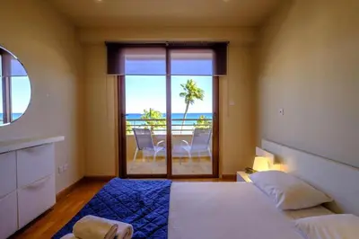 a bedroom with a bed and a view of the ocean at Les Palmiers Beach Boutique Hotel & Luxury Apartments in Larnaka