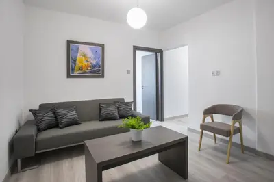 a living room with a couch and a table and a chair at Blazer Residence in Larnaka