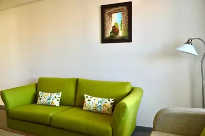 a green couch in a living room with a lamp at Lordos Hotel Apartments Nicosia in Nicosia
